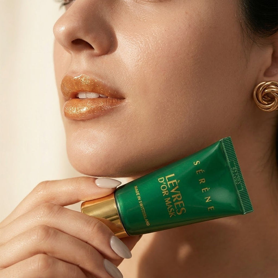 Woman holding a green lip mask tube with gold accents